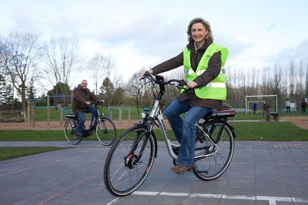 Easy E-Biking - woman riding e-bike yellow vest, helping to make electric biking practical and fun