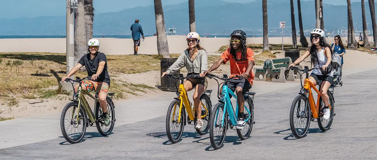 Easy E-Biking - Mokwheel Mesa e-bike, woman riding beach road, helping to make electric biking practical and fun
